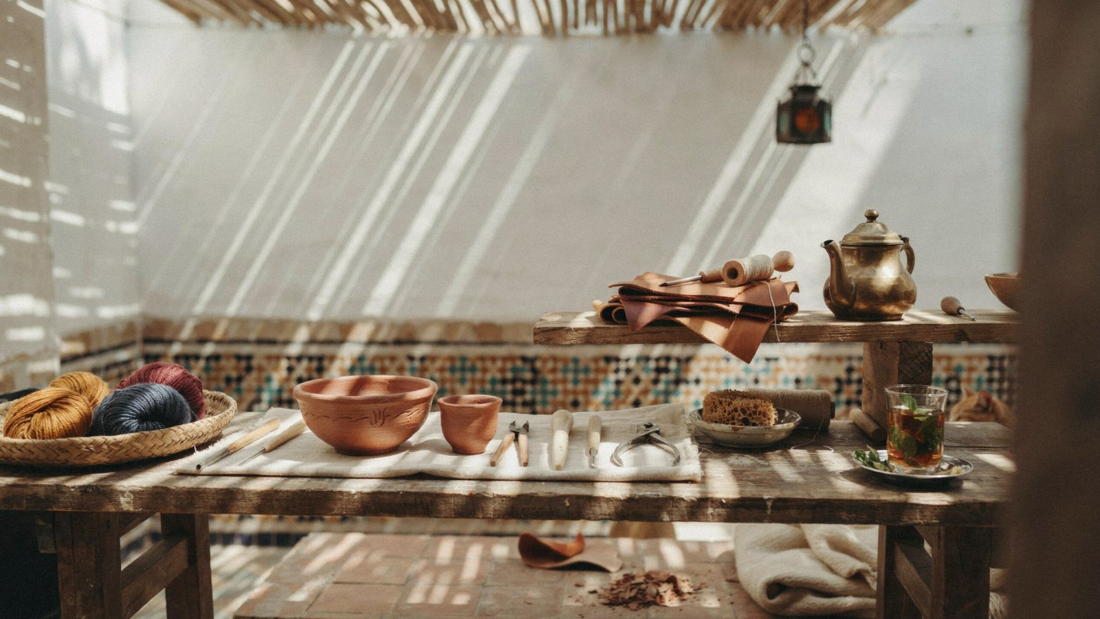Artisan tools and raw materials laid out on a workbench at a Marrakech Workshop