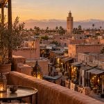 Travelers walking through a Marrakech medina lane at golden hour during a step-by-step city guide - Things do to in marrakech
