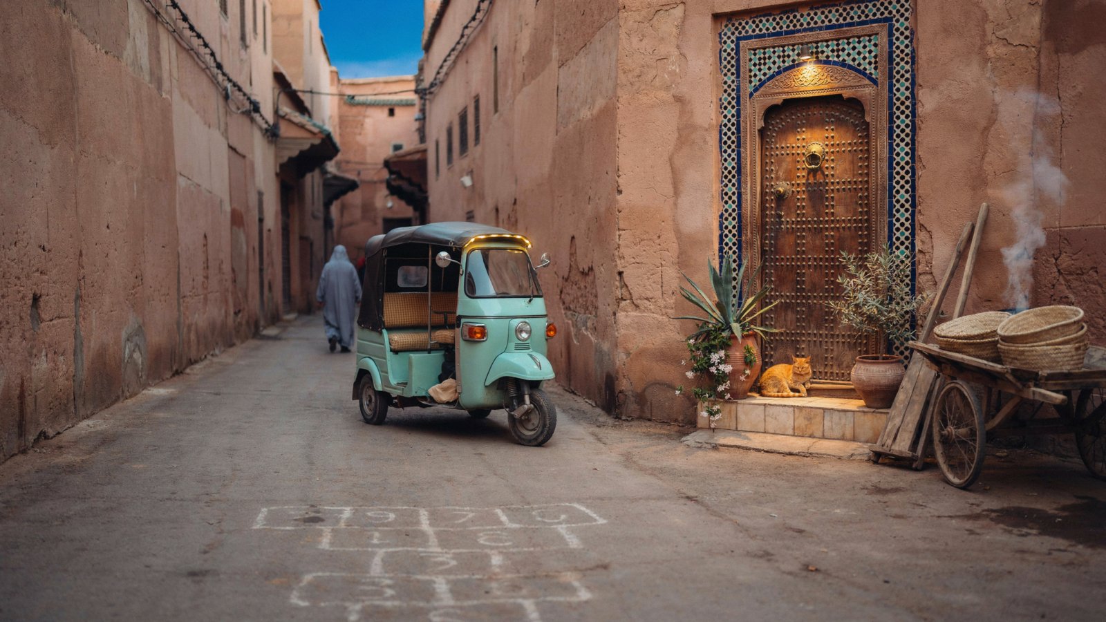 A green tuk tuk parked on a narrow lane in the Marrakech medina at golden hour - Tuk Tuk Marrakech